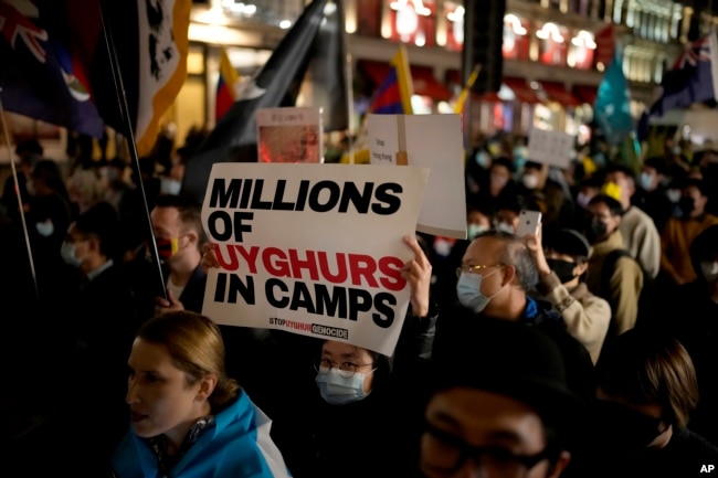 FILE - Demonstrators supporting Tibetans, Uyghurs and Hong Kongers take part in a protest against the Chinese Communist Party, as they march along Regent Street towards the Chinese Embassy, in London, on Oct. 1, 2021.