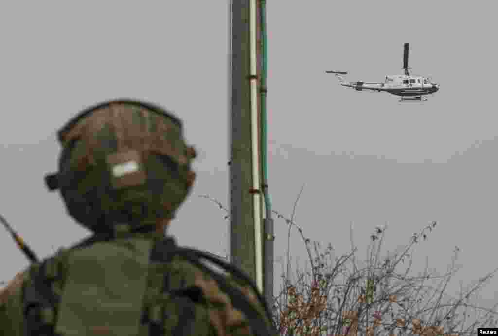 An Israeli soldier looks at a U.N. helicopter flying over the Israel-Lebanon border near the northern town of Metula, Israel, Dec. 29, 2013.&nbsp;