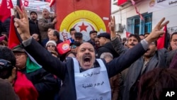 Tunisian workers stage a protest in front of the national union headquarters in the capital Tunis, Jan. 17, 2019.