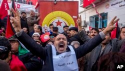 Des travailleurs tunisiens organisent une manifestation devant le siège du syndicat national dans la capitale Tunis, le 17 janvier 2019.