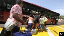 Deported Colombians prepare to board a bus that will take them to the border with Colombia, from San Antonio del Tachira, Venezuela, Aug. 25, 2015.