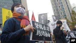 资料照：声援香港反送中运动以及新闻自由的台湾民众在台北的中国银行外举牌示威。（2021年12月30日）