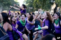 FILE - Women participate in a demonstration to commemorate International Women's Day in Buenos Aires, Argentina.