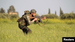 A rebel fighter is seen aiming his weapon in the countryside near Aleppo, Syria.