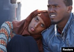 Migrants wait to disembark from the Italian coastguard vessel Peluso in the Sicilian harbour of Augusta, Italy, May 13, 2016.