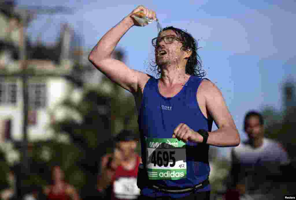 A runner douses himself with water during the Marabana 2014 half marathon race in Cuba.