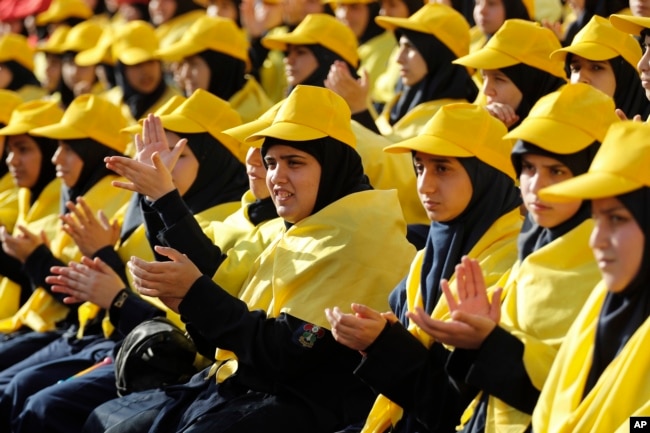 Hezbollah supporters applaud as they listen to Hezbollah leader Sayyed Hassan Nasrallah on a televised speech on giant screens during an election campaign in a southern suburb of Beirut, Lebanon, April 13, 2018. Nasrallah said a recent attack on an air base ushered in a new phase that puts Israel in a state of "direct confrontation" with Iran.