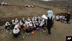 In this April 5, 2017 photo, Afghan students attend school classes in an open air primary school on the outskirts of Kabul, Afghanistan. 