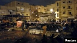 People gather at the site of twin car bombs in Benghazi, Libya, Jan. 23, 2018.