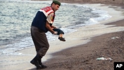 A paramilitary police officer carries the lifeless body of a migrant child near the Turkish resort of Bodrum, Sept. 2, 2015.