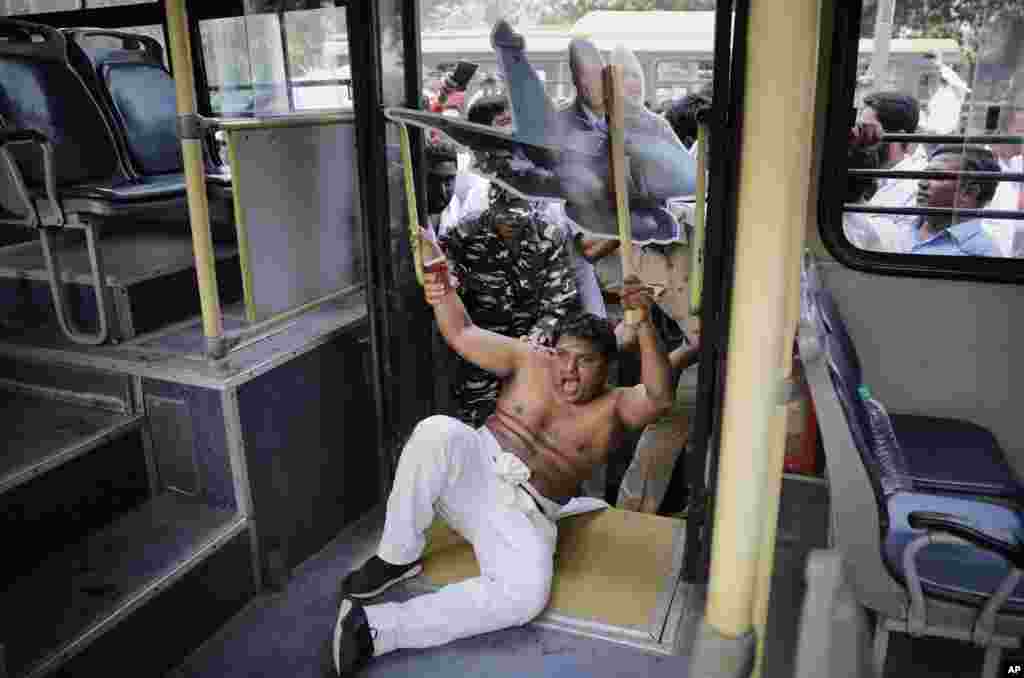 Indian police detain a Congress Party worker during a protest near the official residence of the Indian prime minister in New Delhi.