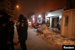 Romanian gendarmes cordon off a part of a street as firefighters work at the scene of a blaze that destroyed a night club in Bucharest, Romania, Jan. 21, 2017.