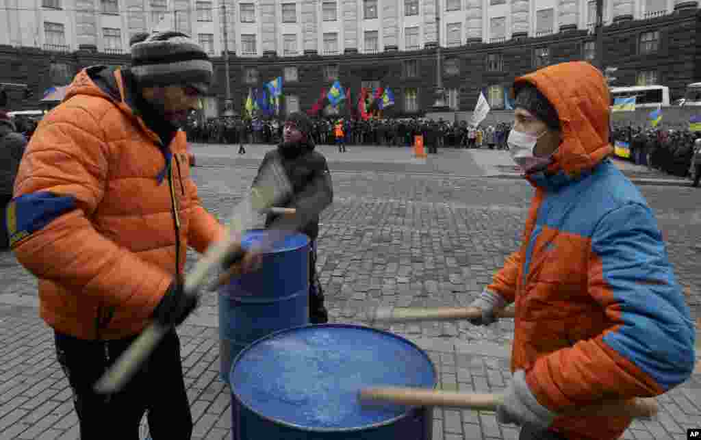 Protesters drum on empty barrels as they rally in front of a government building in Kyiv, Dec. 5, 2013.