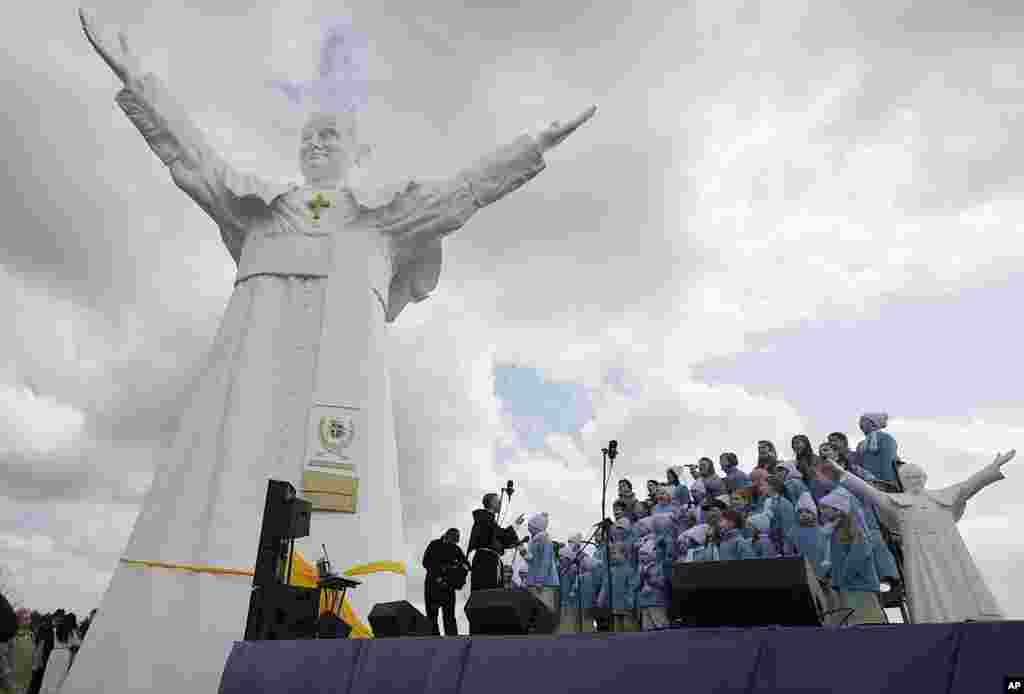 A children&#39;s choir takes part in the unveiling ceremony of the statue of the late Pope John Paul II in Czestochowa, Poland. Archbishop Waclaw Depo unveiled the 13.8-meter (45.3-foot) white fiberglass figure that was funded by a businessman, Leszek Lyson, in gratitude for what he believes was an intervention by the late pontiff in saving his drowning son.