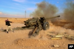 FILE - Syrian government troops fire at Islamic State group positions near Mahin, Syria, Jan. 30, 2016.