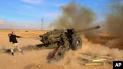 FILE - Syrian government troops fire at Islamic State group positions near Mahin, Syria, Jan. 30, 2016.