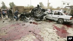 Bloodstains are seen on the ground near damaged vehicles at the site of a bomb attack in Kirkuk, 250 km (155 miles) north of Baghdad, May 19, 2011