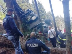 Polisi dan tim penyelamat berada di lokasi jatuhnya kereta gantung di Italia, Minggu (23/5).