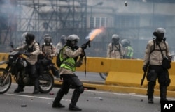 FILE - A police officer fires tear gas against anti-government protesters in Caracas, Venezuela, April 20, 2017.
