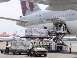 Pekerja mengenakan masker menurunkan Moderna hasil kerjasama internasional Indonesia-Amerika Serikat melalui fasilitas multilateral COVAX, di terminal kargo Soekarno Hatta International, 11 Juli 2021. (Foto: Courtesy Biro Pers via Reuters)