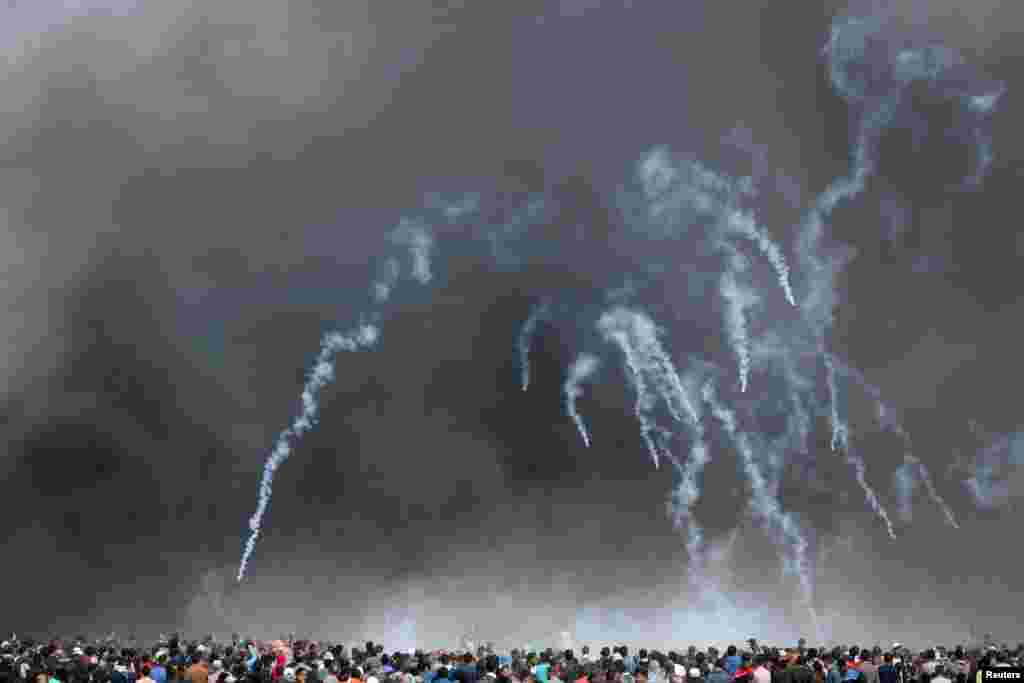 Tear gas canisters are fired by Israeli troops at Palestinian demonstrators during clashes at a protest demanding the right to return to their homeland, at the Israel-Gaza border in the southern Gaza Strip.