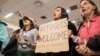 A woman holds a sign during a protest against the travel ban imposed by U.S. President Donald Trump's executive order, at Dallas/Fort Worth International Airport in Dallas, Texas, Jan. 28, 2017.