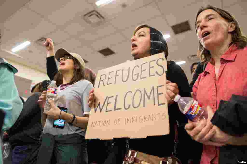 A woman holds a sign during a protest against the travel ban imposed by U.S. President Donald Trump's executive order, at Dallas/Fort Worth International Airport in Dallas, Texas, Jan. 28, 2017.