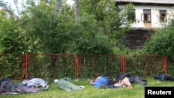 Migranti spavaju u parku nakon požara u kampu u Velikoj Kladuši, 1. juni 2019.