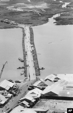FILE - Military traffic is halted as U.S. Army engineers finish repairing a pontoon bridge damaged by a Viet Cong underwater mine, August 1968. Linking Saigon with the Mekong Delta, the bridge over the Oriental River replaced the permanent bridge, blown up by the enemy.