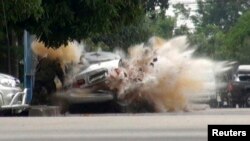 FILE - A car bomb explodes as a member of a Thai bomb squad checks it in Narathiwat province, south of Bangkok July 1, 2011. The bomb planted by suspected insurgents wounded the squad member, police said.