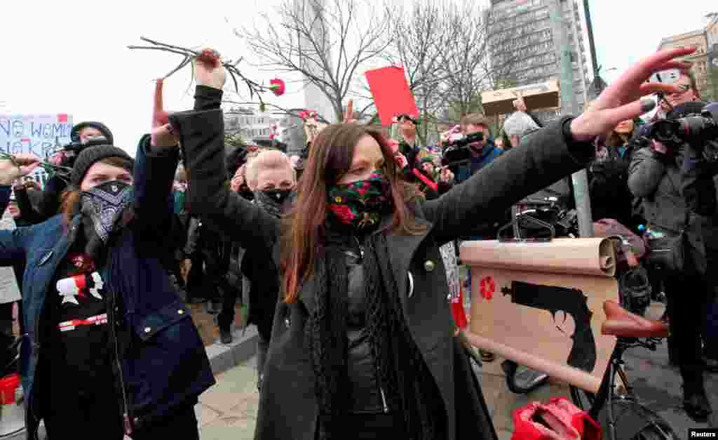 Women throw flowers as they attend a protest during the International Women&#39;s Day, outside the Parliament building in Warsaw, Poland, March 8, 2017.