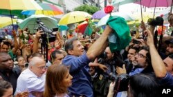 Workers' Party presidential candidate Fernando Haddad holds a Brazilian flag after casting his vote in the presidential election in Sao Paulo, Brazil, Sunday, Oct. 28, 2018.
