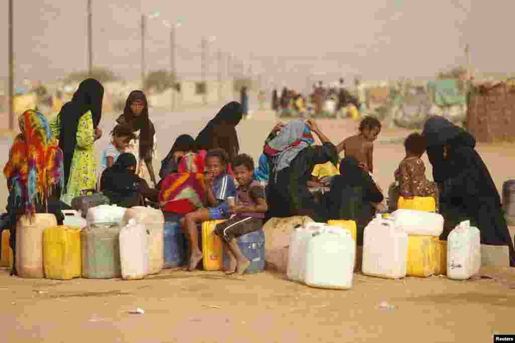 Women and children gather to collect water from a tap at a camp for internally displaced persons (IDPs) in al-Mazraq in the northwestern Yemeni province of Hajja.