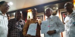 Pendeta Sitorus (batik kuning) dan Bupati Bantul Suharsono menunjukkan surat kesepakatan yang mereka tandatangani. (Foto: VOA/ Nurhadi)