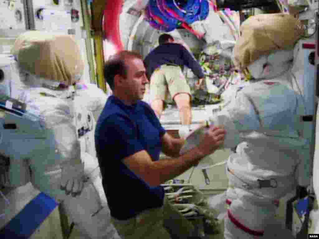 Astronaut Rick Mastracchio (L) checks out the spacesuit that he will wear during a spacewalk with crew member Mike Hopkins at the International Space Station in this undated image taken from video from NASA TV.&nbsp;