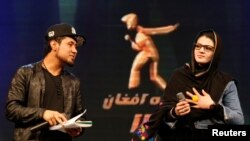 Zulala Hashimi, 18 (R) and Sayed Jamal Mubarez, 23 (L) singer finalists of the music contest 'Afghan Star', rehearse for the show in Kabul, Afghanistan, March 19, 2017.