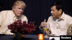 U.S. President Donald Trump talks with Philippines President Rodrigo Duterte during the gala dinner marking ASEAN's 50th anniversary in Manila, Philippines, Nov. 12, 2017.