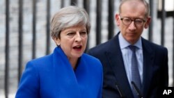 PM Inggris Theresa May berbicara kepada media didampingi suaminya Philip (kanan), di Downing street di London, Jumat (9/6). 