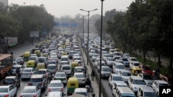 FILE - Vehicles move slowly at a traffic intersection after the end of a two-week experiment to reduce the number of cars to fight pollution in in New Delhi, India, Jan. 16, 2016. 