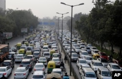 FILE - Vehicles move slowly at a traffic intersection in New Delhi, India, Jan. 16, 2016.