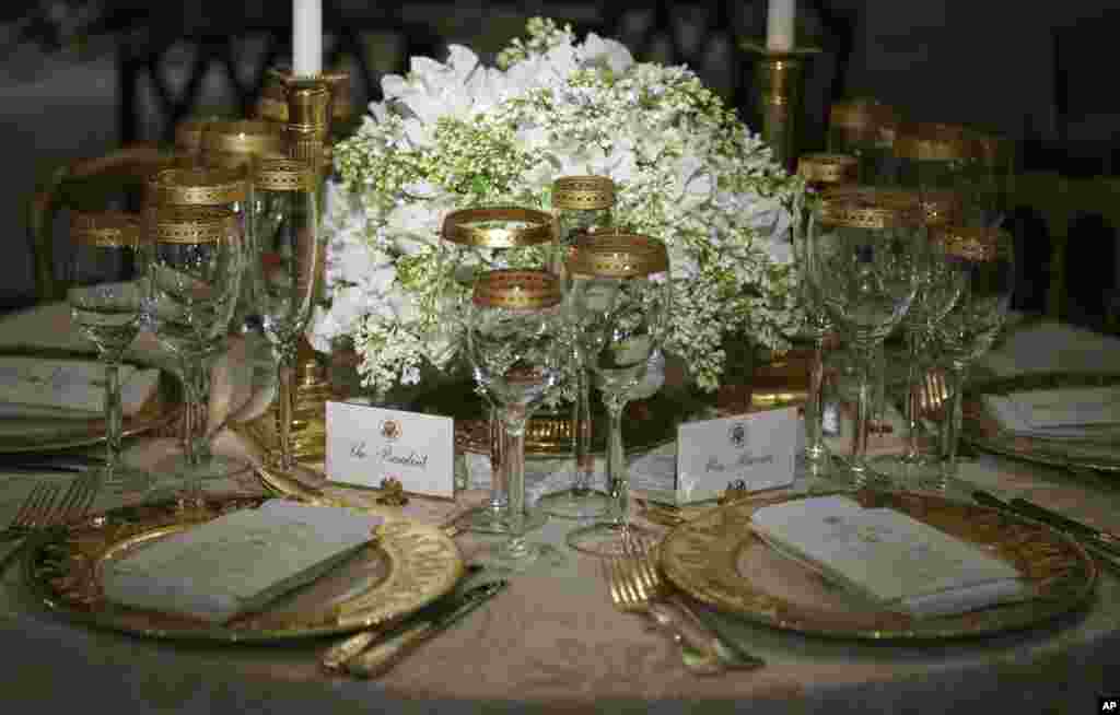 Place settings for a previous President Donald Trump State dinner is seen in the China Room during a 2018 Christmas preview at the White House in Washington, Monday, Nov. 26, 2018. A name card for President Donald Trump is left and another for French Pres