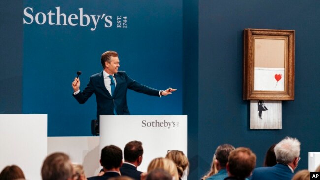 In this handout photo provided by Sotheby's Auction House, the auction for Banksy's