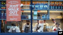 Workers as seen from a sidewalk window as they assemble sandwiches in an Amazon Go store Monday, Jan. 22, 2018, in Seattle. (AP Photo/Elaine Thompson)