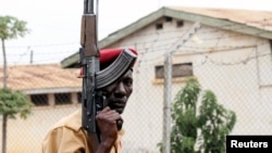 FILE - A prison officer, armed with a rifle, stands guard at Lira Central Prison in northern Uganda, Feb. 13, 2013.