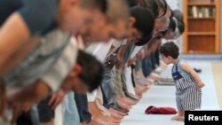 Seorang anak kecil berada di depan jamaah muslim yang sedang melakukan shalat pada bulan Ramadan (foto: dok). Sebuah organisasi muslim AS menyelenggarakan Sayembara Fotografi Internasional – IRPC bertema 'Menangkap Semangat Ramadan'.