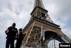 FILE - French police patrol near the Eiffel tower as part of security measures in Paris, France, July 13, 2017.