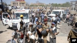 Anti-government protesters carry fellow protesters at a makeshift clinic after they were injured in a demonstration demanding the ouster of Yemen's President Ali Abdullah Saleh in Sanaa October 25, 2011.