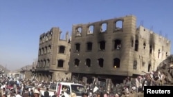 FILE - People gather at the site of an airstrike by the Saudi-led coaltion in Yareem city in Ibb province, Yemen, March 31, 2015. 