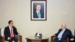 In this photo released by the Syrian official news agency SANA, Syria's Foreign Minister Walid al-Moallem, right, meets with his Venezuelan counterpart Jorge Arreaza, in Damascus, April 4, 2019. 