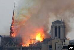 Flames rise from Notre Dame cathedral as it burns in Paris, April 15, 2019.